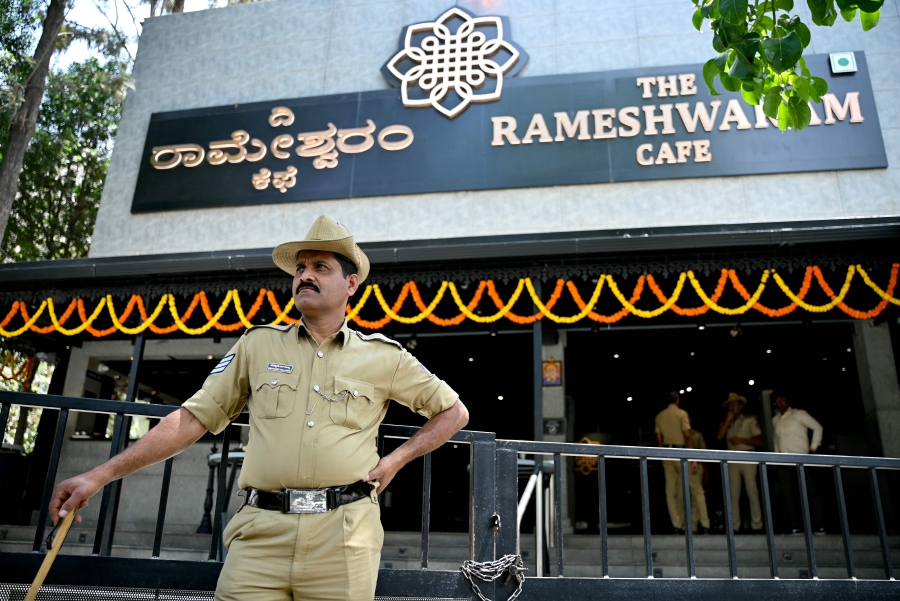 A police personnel stands guard near the site of a bomb blast at Rameshwaram Cafe in Bengaluru on March 2, 2024. AFP