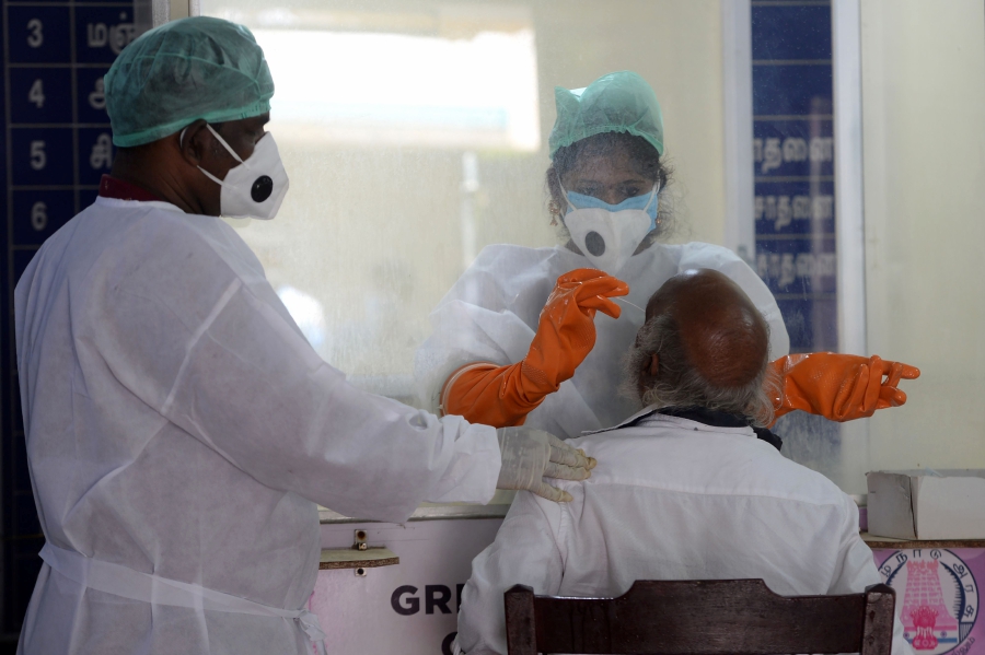 Medical technician collect a sample from a elderly man at a COVID-19 testing centre during a government-imposed nationwide lockdown as a preventive measure against the COVID-19 coronavirus in Chennai. (Photo by Arun SANKAR / AFP)