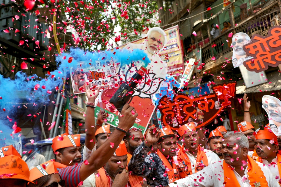 Supporters of Narendra Modi, India's Prime Minister and leader of Bharatiya Janata Party (BJP) carry his cut-outs as they celebrate vote counting results for India's general election in Varanasi. (Photo by Niharika KULKARNI / AFP)