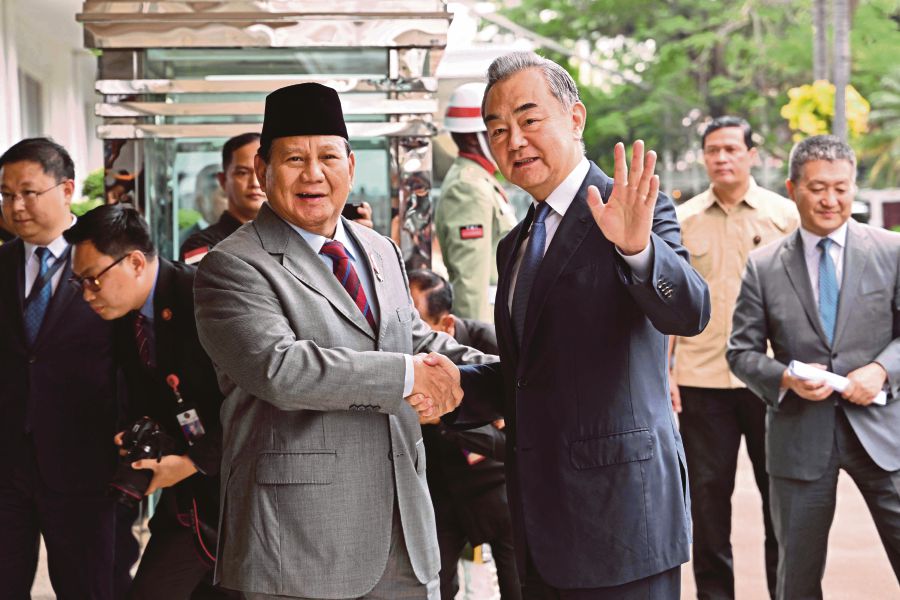 Indonesian Defence Minister and President-elect Prabowo Subianto (left) and China's Foreign Minister Wang Yi (right) pose for a photograph during a visit at the Defence Ministry office in Jakarta. (Photo by Adek BERRY / AFP)