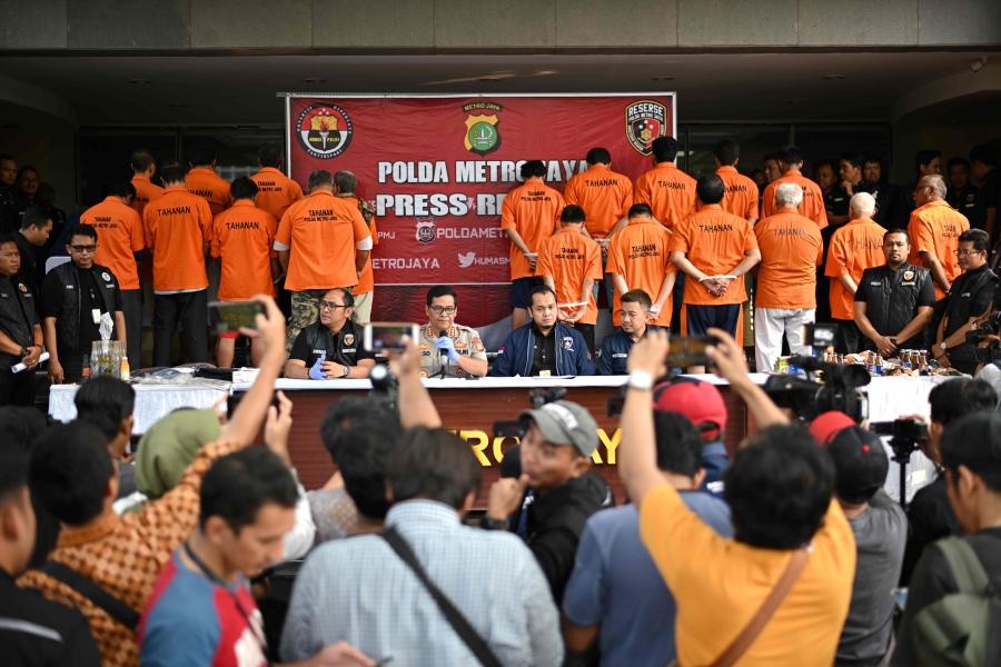 Detained suspects, accused of making Molotov cocktails ahead of mass demonstrations, have their backs facing journalists as Jakarta Police spokesman Chief Commissioner Argo Yuwono (center) briefs a media conference in Jakarta on October 18, 2019. - Indonesia is on high alert ahead of President Joko Widodo's second-term inauguration on October 20, after Islamic State-linked militants tried to assassinate a government minister.-AFP