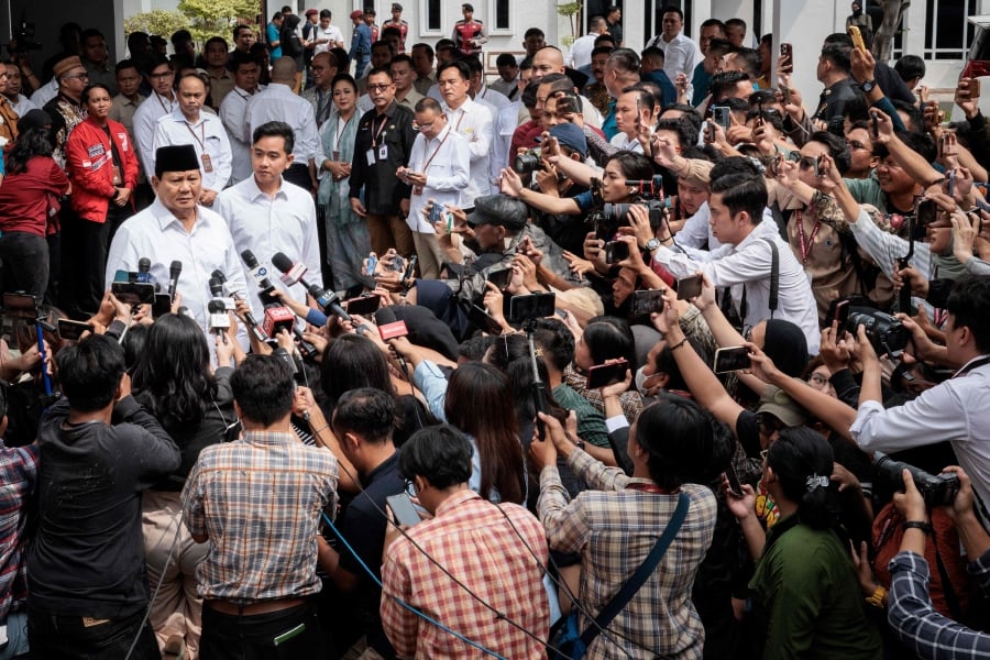 Indonesia's president-elect Prabowo Subianto (left) speaks to the media with vice president-elect Gibran Rakabuming Raka (second from left) as they arrive at the plenary session of the General Elections Commission (KPU). (Photo by Yasuyoshi CHIBA / AFP)