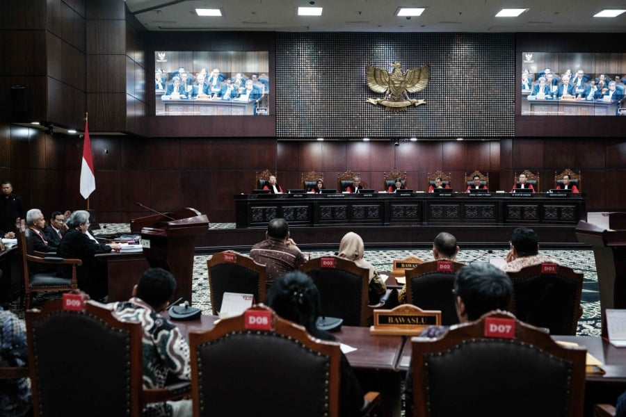 Chief Justice of the Constitutional Court of Indonesia Suhartoyo (top, fifth from right) and judges attend the first hearing of the petition by presidential election challenger Ganjar Pranowo. (Photo by Yasuyoshi CHIBA / AFP)