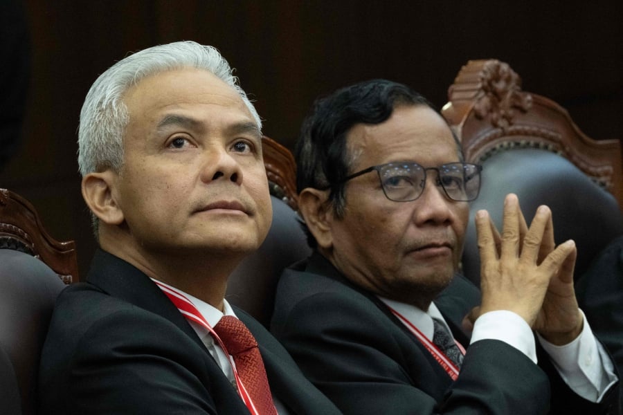 Indonesia's presidential election challenger Ganjar Pranowo (left) and vice presidential election challenger Mahfud MD (right) attend the first hearing of their petition over the February 2024 elections, which was decisively won by Defence Minister Prabowo Subianto amid allegations of irregularities and fraud, at the Constitutional Court in Jakarta. (Photo by Yasuyoshi CHIBA / AFP)