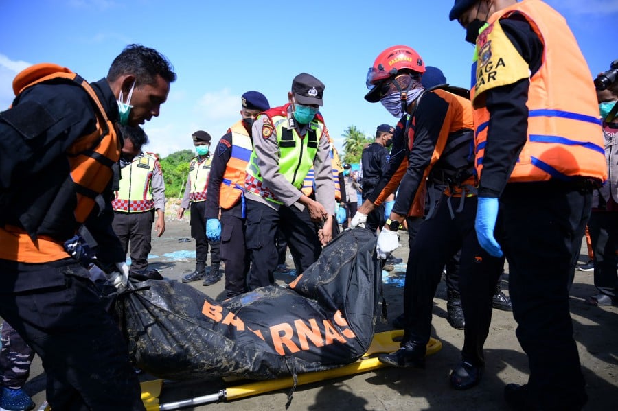 Members of the National Search and Rescue Agency (BASARNAS) carry a bodybag during their search operation for missing Rohingya refugees after 69 refugees were rescued from their overturned boat two days ago in the sea near Calang, West Aceh, on March 23, 2024. Survivors told local authorities that as many as 151 refugees were onboard the boat. - AFP pic