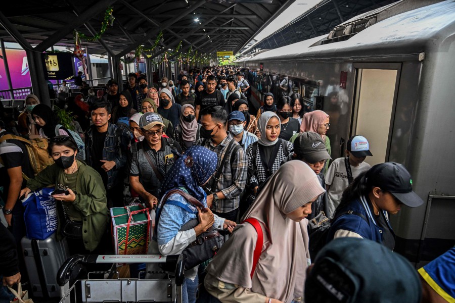 Passengers prepare to board a train to return home ahead of Aidilfitri, which marks the end of the fasting month (Ramadan), at Gubeng station in Surabaya on Sunday (April 7). — AFP
