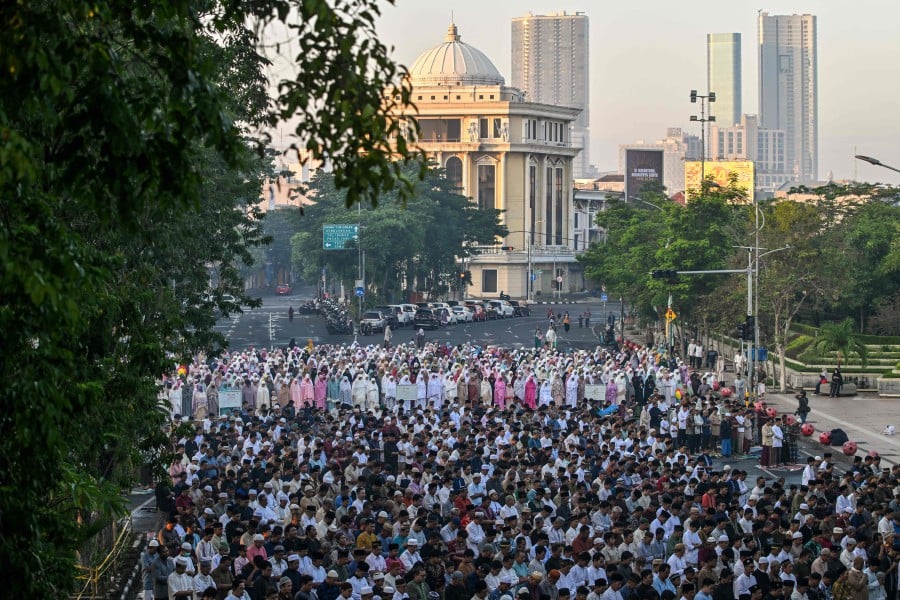 Indonesian Muslims perform the Eid al-Adha morning prayer along a road in Surabaya yesterday (June 17) in conjunction with Hari Raya Aidiladha. Former East Java governor Khofifah Indar Parawansa is optimistic that East Java will become the centre of Indonesia’s economy, given its vast potential in marine, fisheries, and fishing products. — AFP