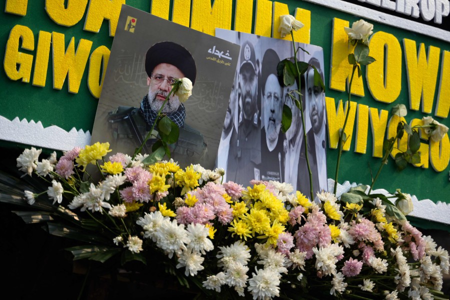 Portraits of Iran's late President Ebrahim Raisi are seen with flower bouquets outside the Iranian embassy in Jakarta today (May 21), following his death in a helicopter crash in a remote area of northwestern Iran. — AFP