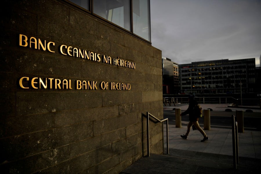 FILE PHOTO: A man walks past the Central Bank of Ireland in Dublin, Ireland, February 11, 2022. REUTERS/Clodagh Kilcoyne/File Photo