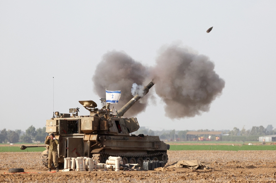 A picture taken in southern Israel near the border with the Gaza Strip shows Israeli artillery firing towards Gaza, amid continuing battles between Israel and the militant group Hamas. (Photo by JACK GUEZ / AFP)