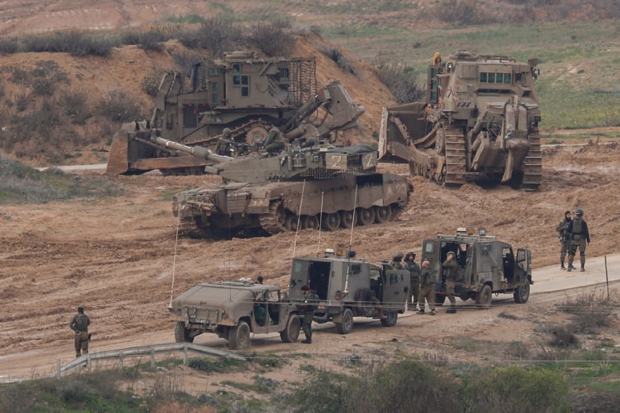 Israeli military vehicles gather, amid the ongoing conflict between Israel and the Palestinian fighter group Hamas, near the Israel-Gaza border, in southern Israel. (REUTERS/Tyrone Siu)