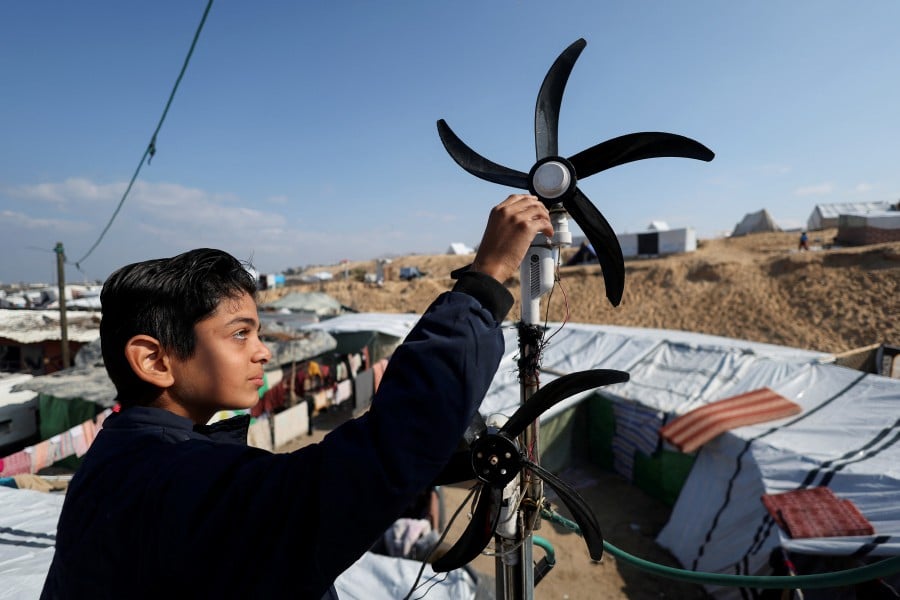 Displaced Palestinian teenager Hussam Al-Attar, nicknamed by people 'Newton', works on wind turbines, that he uses to light up his shelter during power cut, at a tent camp in Rafah, in the southern Gaza Strip, February 6, 2024. REUTERS PIC