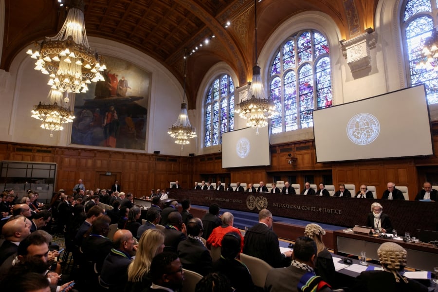People sit inside the International Court of Justice (ICJ) on the day of the trial to hear a request for emergency measures by South Africa, who asked the court to order Israel to stop its military actions in Gaza and to desist from what South Africa says are genocidal acts committed against Palestinians during the war with Hamas in Gaza, in The Hague, Netherlands. (REUTERS/Thilo Schmuelgen)