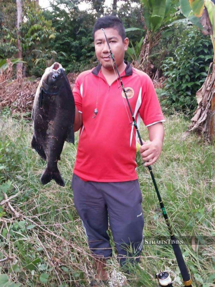 Ilham Norhakim with a piranha caught in an undisclosed river. - NSTP/ ROSLI ZAKARIA