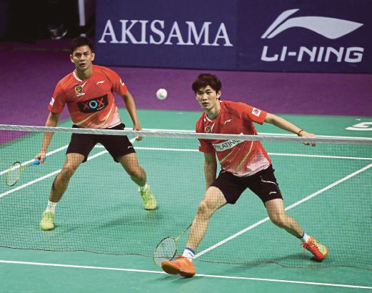 Petaling BC's Chen Tang Jie returning a shot as his men's doubles teammate Andrei Adistia looks on during their match against Petaling Jaya BC at the Gem in Mall, Cyberjaya. 