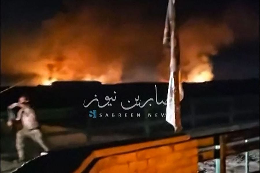 This image grab from a UGC video posted on April 20, 2024, shows fire and smoke rising in the central province of Babylon after an alleged bombing overnight on an Iraqi military base housing a coalition of pro-Iranian armed groups. The explosion hit the Kalsu military base in Babylon province south of Baghdad, where Iraq's Popular Mobilization Forces, or Hashed al-Shaabi, is stationed, according to an interior ministry source and a military official. - (Photo by UGC / AFP) 