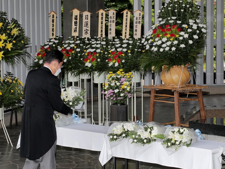 Japanese Prime Minister Fumio Kishida places a bouquet of flower on an altar as he visits the Chidorigafuchi National Cemetery for the War Dead in Tokyo on August 15, 2022, to mark the 77th anniversary of Japan's surrender in World War II in 1945. (Photo by JIJI Press / AFP) 