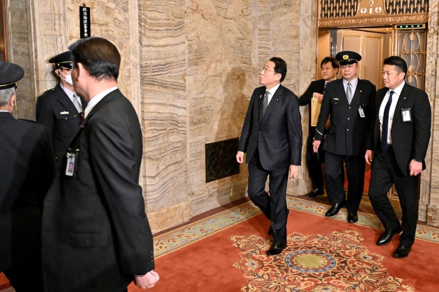 Japan's Prime Minister Fumio Kishida (centre) arrives to the 5th committee room where the political ethics committee will be held at Parlieament, over a money scandal rocking the ruling Liberal Democratic Party, in Tokyo. (Photo by Kazuhiro NOGI / AFP)