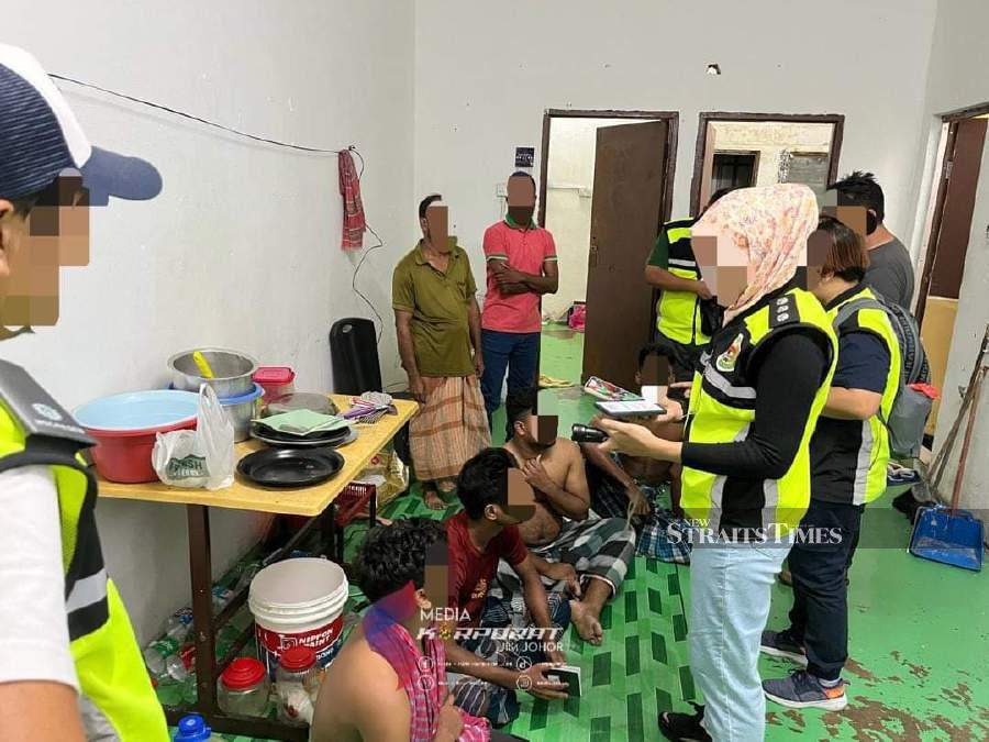 Johor Immigration Department enforcement officers detaining 26 undocumented foreigners for overstaying in a series of raids conducted in Johor Baru. - Pic courtesy of Johor Immigration Department