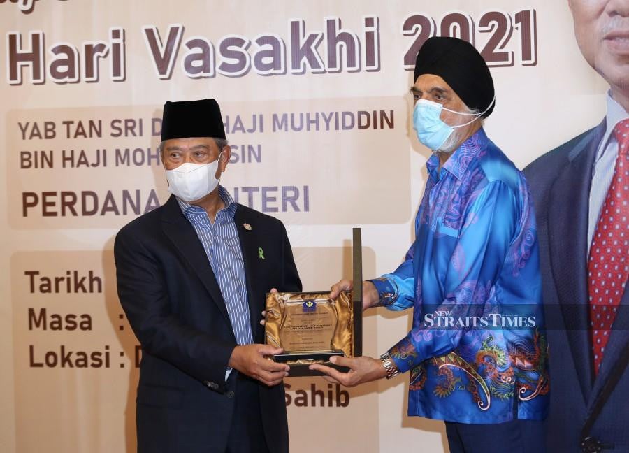 This April 12 pic shows Prime Minister Tan Sri Muhyidin Yassin accepting a souvenir from the Malaysian Gurdwaras Council (MGC) president Jagir Singh during a gathering in conjunction with Vaisakhi celebration at Gudwara Sahib in Petaling Jaya. -NSTP/HAZREEN MOHAMAD