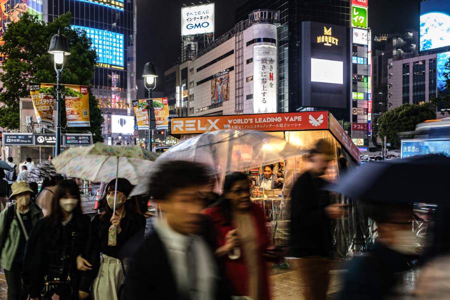 People walk with umbrellas in front of a news stand (C) during a rainy evening in Tokyo's Shibuya district. - Bosses worried about turnover or wondering how long a new hire will stick around can now turn to artificial intelligence for a heads-up on who might be next out the door. - AFP pic