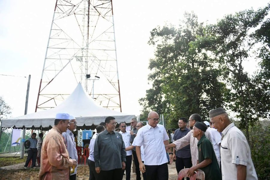 Pahang Communications and Multimedia Committee chairman Fadzli Mohamad Kamal(middle, in white) while attending the completion works for Jendela phase one telecommunication tower at Kampung Salang, Lipis. - Pic courtesy of Fadzli’s FB