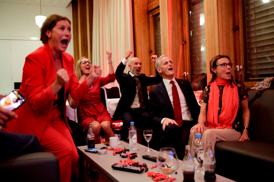 Norway's Labor leader Jonas Gahr Store (2nd R) cheers after seeing the exit poll results of the Labor Party's election event in Folkets Hus, in Oslo, during the 2021 Norwegian parliamentary elections. - AFP PIC