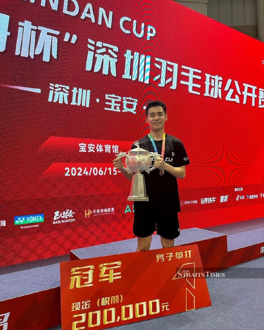 Cheam June Wei with his trophy and mock cheque at the Lin Dan Cup in Bao'an, Shenzhen, China, on Sunday. PIC FROM LIN DAN CUP 