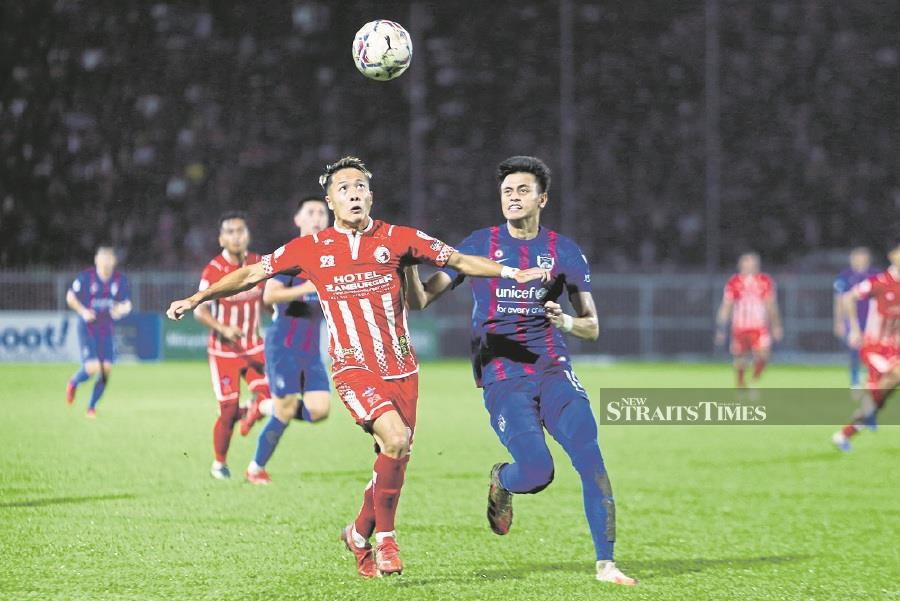 Kelantan’s Kenta Hara (left) and JDT’s Feroz Baharudin in action during Saturday’s Malaysia Cup match at the Sultan Muhd IV Stadium in Kota Baru. -- PIC: NSTP/ NIK ABDULLAH NIK OMAR