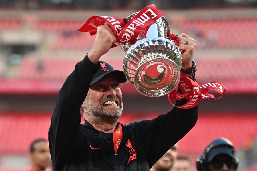 (FILES) Liverpool's German manager Jurgen Klopp celebrates with the trophy after winning the English FA Cup final football match between Chelsea and Liverpool, at Wembley stadium, in London, on May 14, 2022. Jurgen Klopp will manage his last match, at Anfield on May 19, 2024 after announcing in January of the same year, that he would be stepping down at the end of the season. The German coach became the only Liverpool manager to complete the collection of Premier League, Champions League, FA Cup, League Cup, Club World Cup and Community Shield during his nine year tenure. - AFP pic