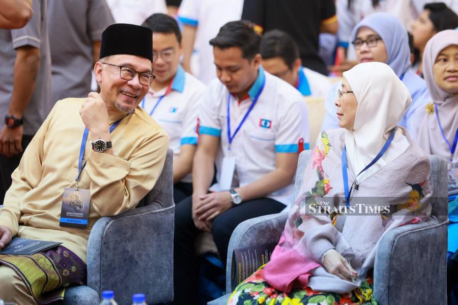 PKR president and Prime Minister Datuk Seri Anwar Ibrahim and wife Datuk Seri Dr Wan Azizah Wan Ismail, herself a former party president, at the PKR Convention in IDCC Shah Alam. NSTP/ASYRAF HAMZAH