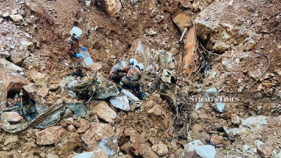 The operation to recover the remains of two victims buried under the debris of a landslide at a limestone quarry in Keramat Pulai, Ipoh, had to be carried out cautiously due to serious hazards at the site. - Pic courtesy of Fire and Rescue Depart