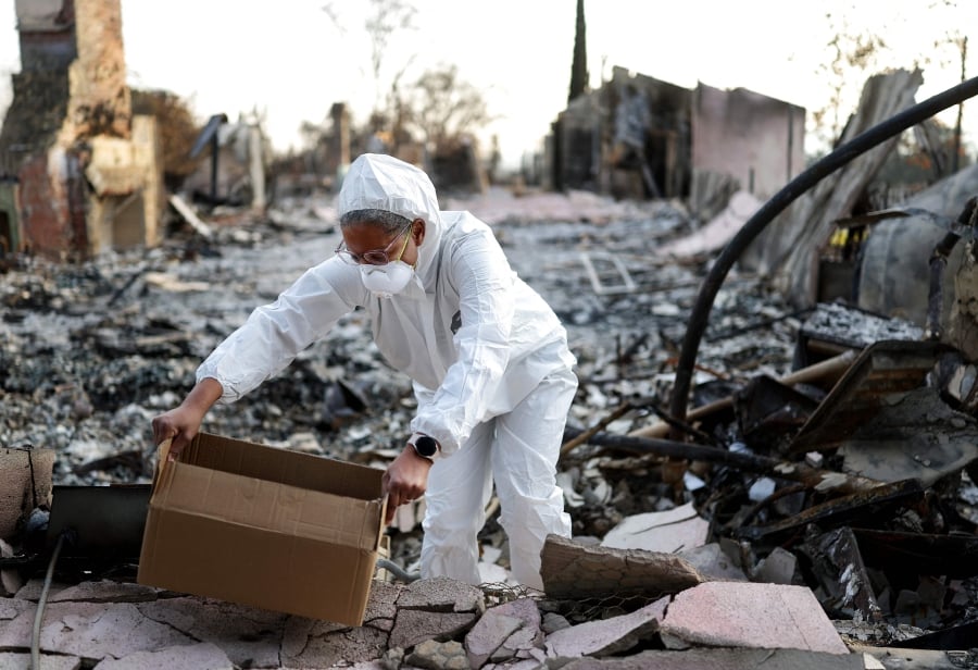 Lay leader Aviana Springs lifts a box containing jars of ashes she collected from the remains of Altadena United Methodist Church which burned in the Eaton Fire on January 31, 2025 in Altadena, California. Springs said collecting the ashes is 'part of our process of grieving and knowing that God is going to do something new.' Many members of the church lost their homes in the fire. Over 12,000 structures, many of them homes and businesses, burned in the Palisades and Eaton Fires.  - AFP pic