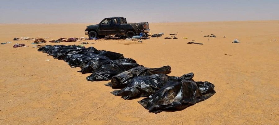 Recovered bodies of migrants lie in bags in the area between Kufra city and Chadian border with Libya June 28, 2022.  - Courtesy of Kufra ambulance service head Ibrahim Belhasan /Handout via REUTERS 
