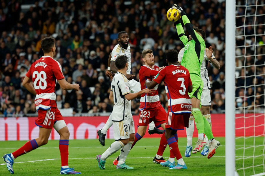 Granada's Spanish goalkeeper Raul Fernandez (Top) catches the ball during the Spanish league football match between Real Madrid CF and Granada FC at the Santiago Bernabeu stadium in Madrid. - AFP pic