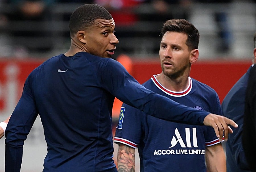 Paris Saint-Germain's French forward Kylian Mbappe talks to Paris Saint-Germain's Argentinian forward Lionel Messi at the end of the French L1 football match between Stade de Reims and Paris Saint-Germain at Auguste Delaune Stadium in Reims on August 29, 2021. (Photo by FRANCK FIFE / AFP)