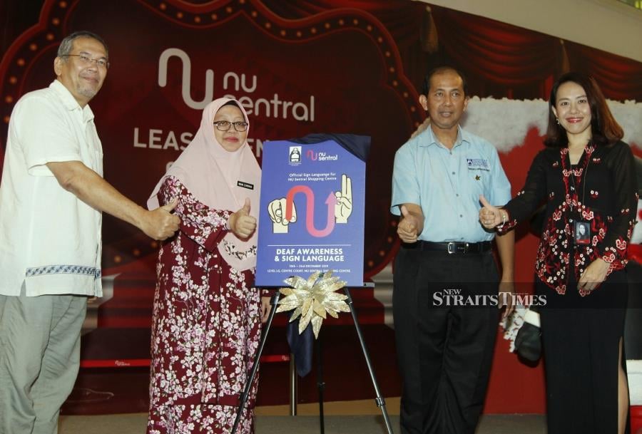 Director of the Social Welfare Department, Wan Zarina Wan Salleh (second from left) and Malaysian Deaf President Tengku Arman Harris Tengku Ismail (second from right) launch the 'Listen with Your Heart' campaign at NU Central. Also present are Sazali Sha'ari (left) and Alice You. -NSTP/MUSTAFFA KAMAL