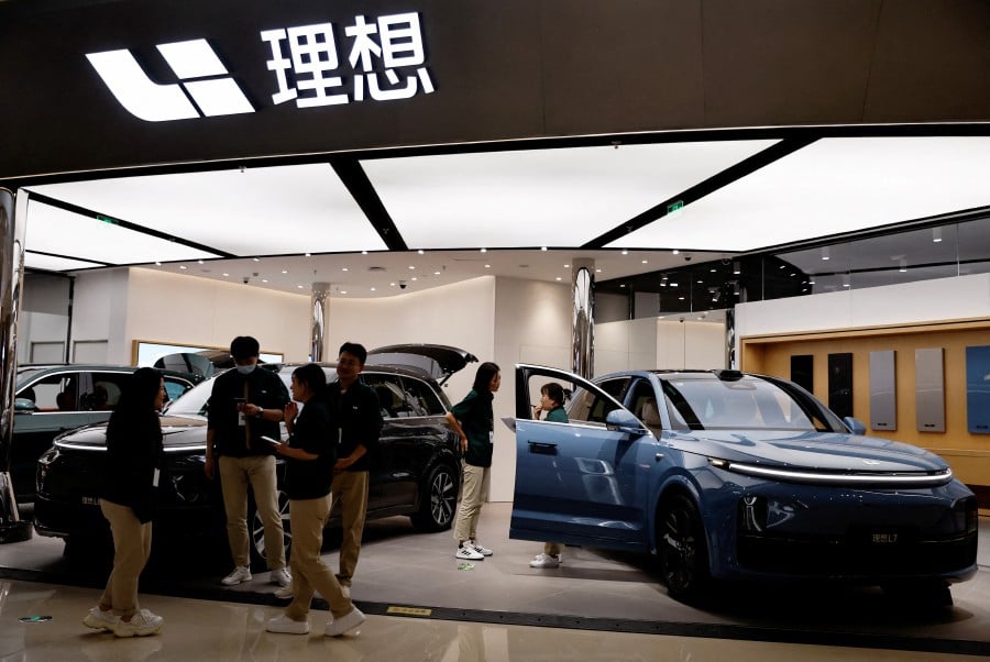 FILE PHOTO: Staff members stand at the booth of Chinese electric vehicle (EV) maker Li Auto, at a shopping mall in Beijing, China November 3, 2023. REUTERS/Tingshu Wang/File Photo