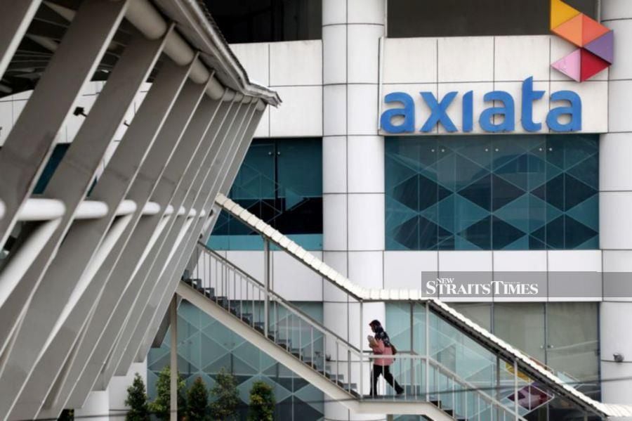 A woman walks past the Axiata headquarters building in Kuala Lumpur, Malaysia. REUTERS/Lim Huey Teng