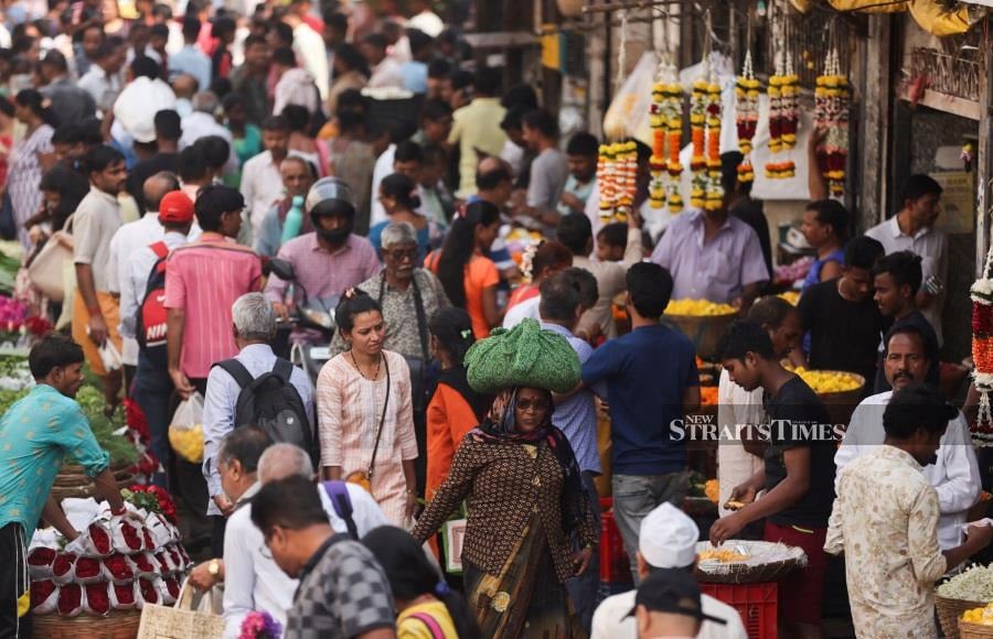 People walk through a crowded market. REUTERS/Francis Mascarenhas