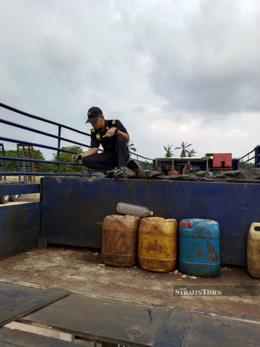 A Domestic Trade and Cost of Living Ministry enforcement personnel inspecting a skid tank during an Op Tiris 3.0 raid at a premises in Simpang Empat, near Hutan Melintang, Perak yesterday. NSTP/ - Courtesy of KPDN PERAK.
