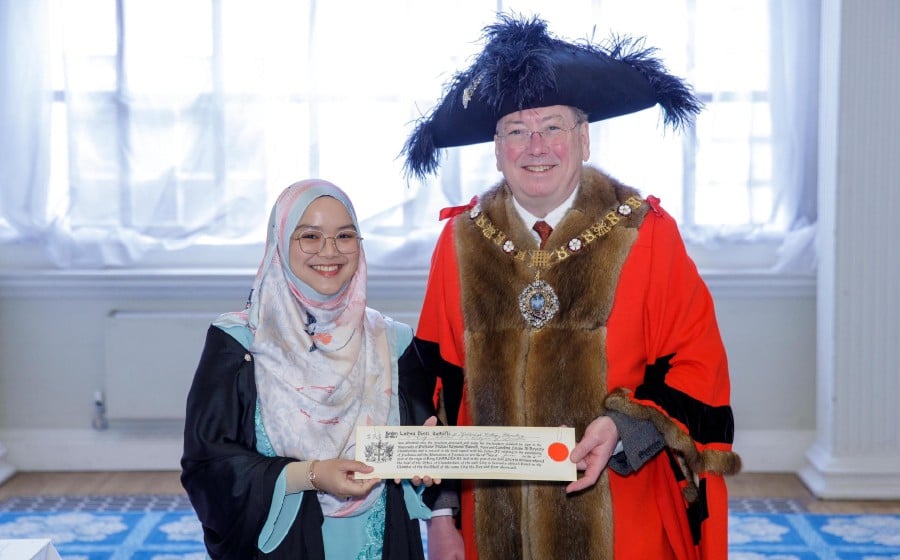 Lubna Zulkifli with her Freedom of The City of London document and the Lord Mayor of the City of London, Prof Michael Mainelli. Pic courtesy of the Lord Mayor of the City of London's Office