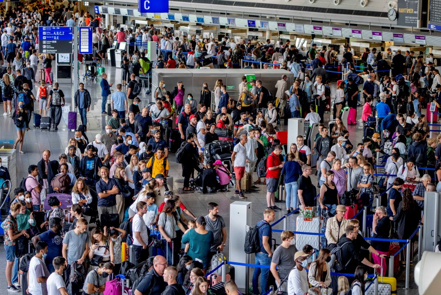 Passengers queue at check in counters at the international airport in Frankfurt, Germany. - AP PIC