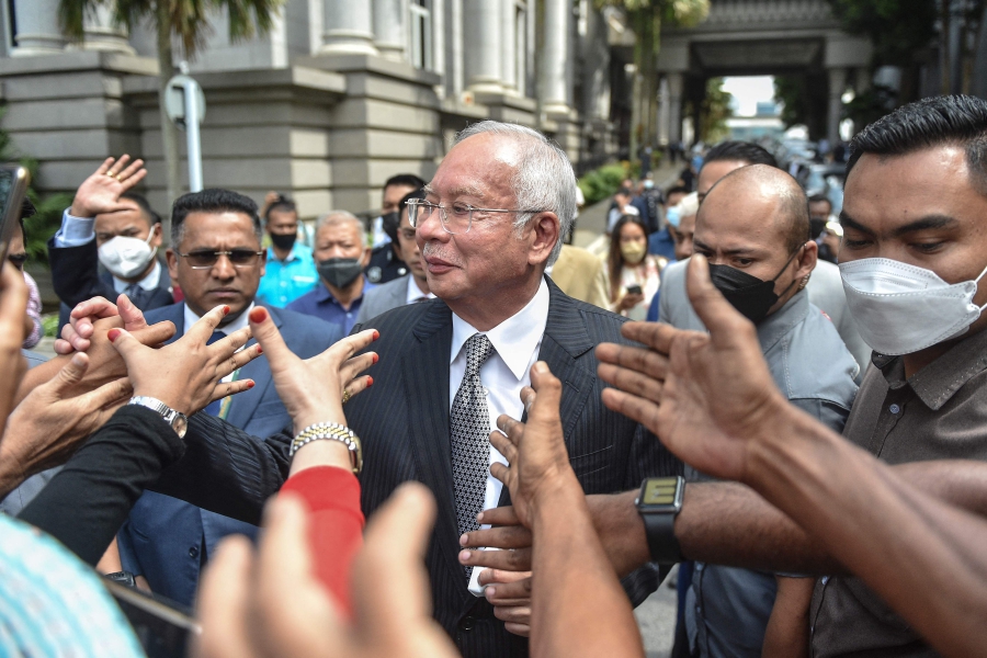 Malaysia's former prime minister Najib Razak greets supporters as he walks out during a break in the trial during an appeal against his corruption conviction over the 1MDB financial scandal, at the federal court in Putrajaya. (Photo by Arif Kartono / AFP)