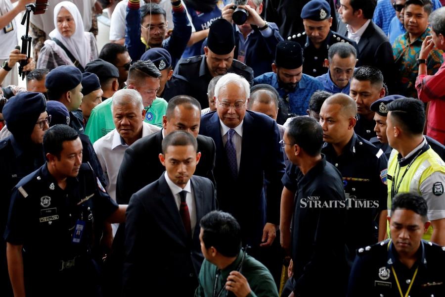 Dressed smartly in a navy blue suit, Datuk Seri Najib Razak arrived at the KL Court Complex in Jalan Duta at about 1.50pm accompanied by his youngest son, Ashman Najib. (Reuters photo)