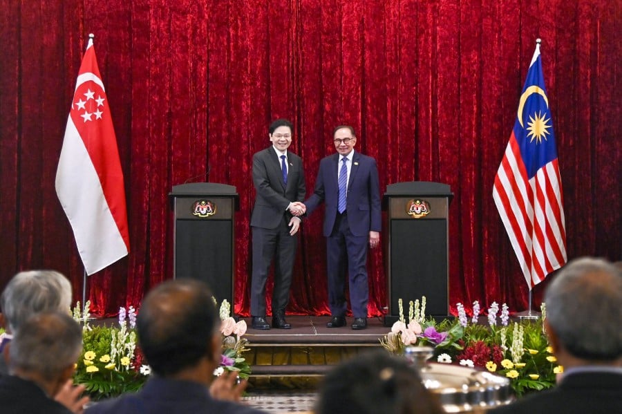 Prime Minister Anwar Ibrahim (Right) and Singapore's Prime Minister Lawrence Wong (Left) shaking hands after their joint press conference in Putrajaya today (June 12). — AFP 