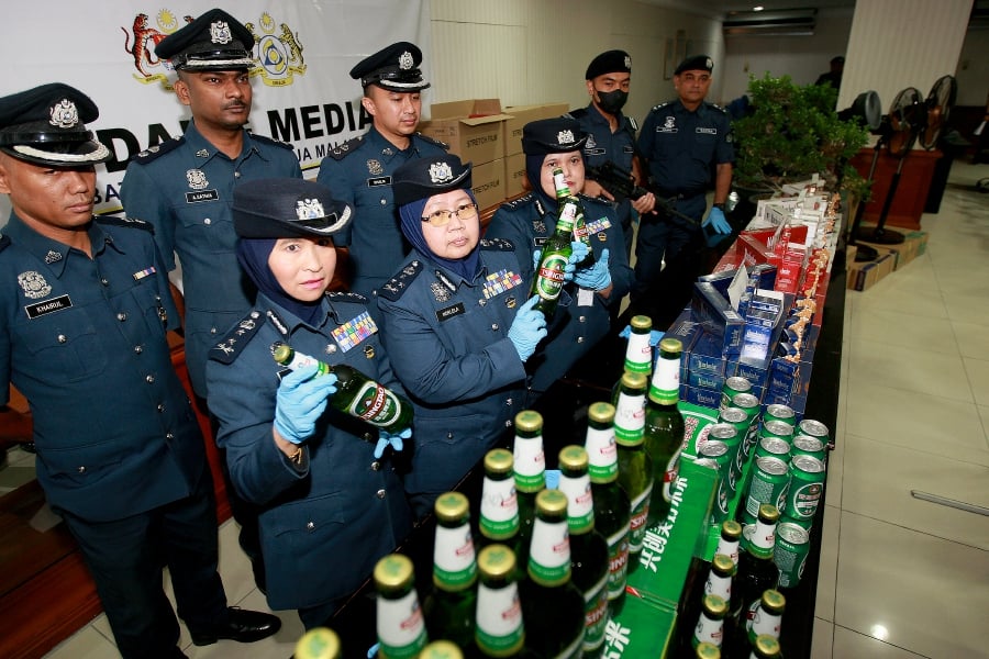Customs Central Zone deputy director Norlela Ismail (front row, 2nd from left) with the seized alcoholic beverages. -- NSTP/FAIZ ANUAR