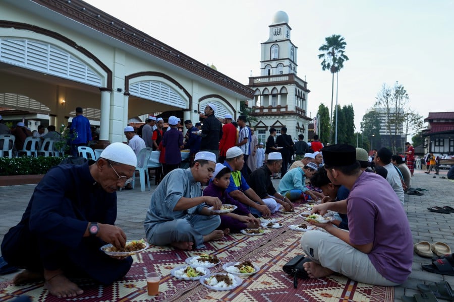Muslim congregation enjoying the breakfast served after Fajr prayers at the Muhammadi mosque in Kota Baru. - BERMAMA PIC
