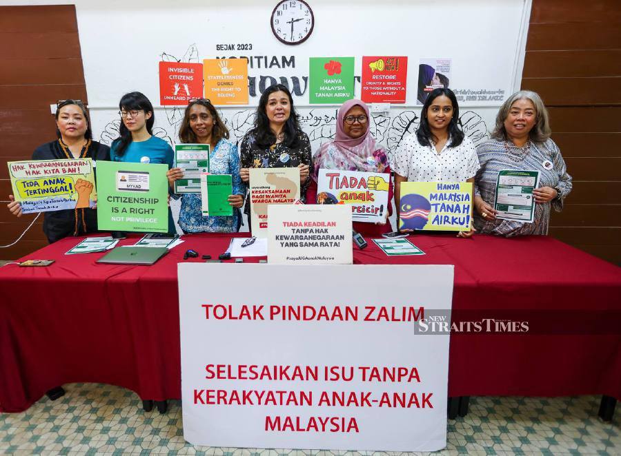 President of Family Frontiers, Suriani Kempe (center), along with other members of Family Frontiers, posing for a photo after a press conference by the Malaysian Citizenship Rights Alliance (MCRA) demanding a review of the remaining three amendments to citizenship in Chow Kit's Street Book. - NSTP/ASWADI ALIAS