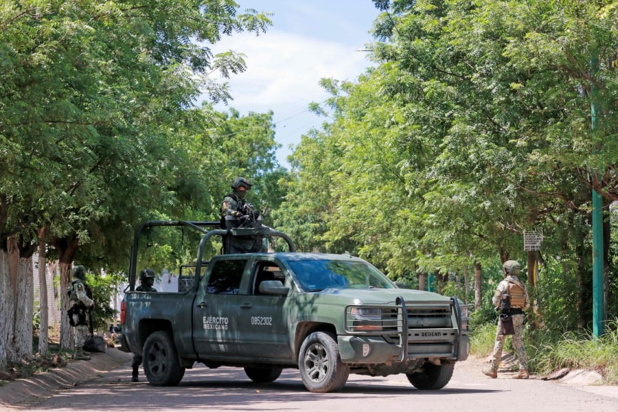 Soldiers of the Mexican Army stand guard as they secure an area during a military operation in Culiacan, Sinaloa State, Mexico. (Photo by Ivan MEDINA / AFP)